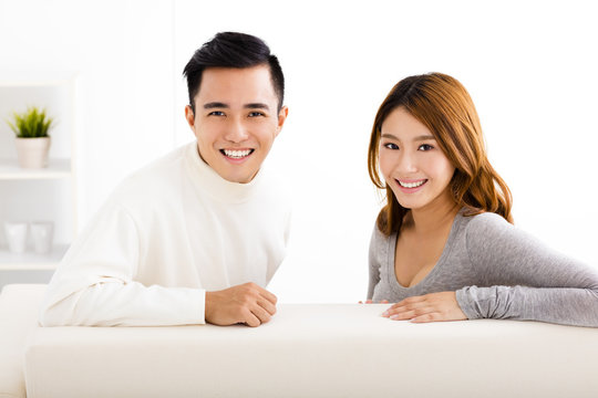 happy young couple sitting in sofa
