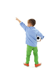 Back view of little boy holding football, points at wall. Rear view
