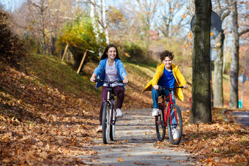 Urban biking - teens riding bikes in city park 