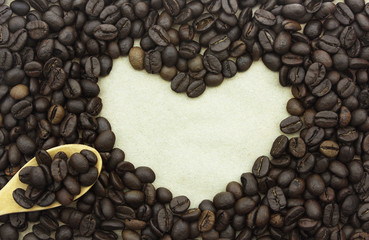 Coffee beans in shape of heart on paper background.