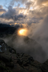 Norwegian landscape :sun rays through the clouds to illuminate a fjord
