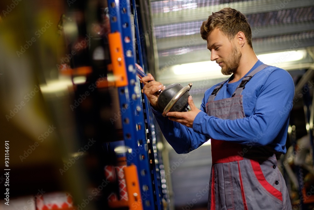 Wall mural Worker on a automotive spare parts warehouse