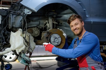 Mechanic checking car brake system in a workshop