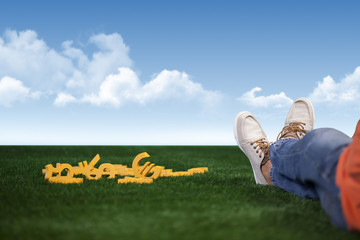 Rich and successful young man is sitting with money on grass