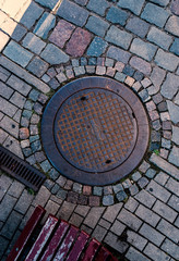 Rust metal manhole cover with rounded tiles