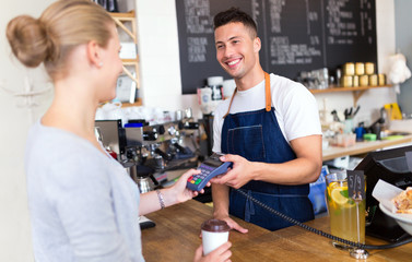 Barista serving customer in coffee shop