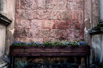 Wooden box on legs with white and blue colors - the background brick wall on the side of the column.