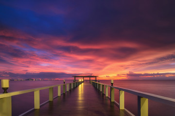 Fototapeta na wymiar Wooded bridge in the port between sunrise.