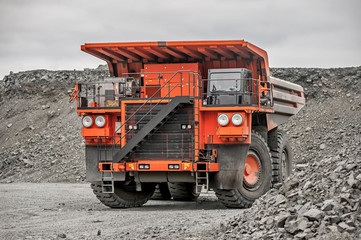 Orange mining vehicle driving in the pit