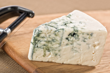 Wedge of creamy delicious gorgonzola blue cheese with cheese knife
