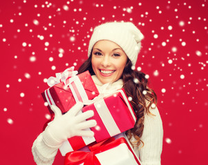 woman in sweater and hat with many gift boxes