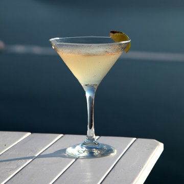 cocktail drink on wood table in front of summer sea background