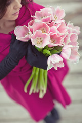 Beautiful woman are walking with a bouquet of tulips in a cities streets