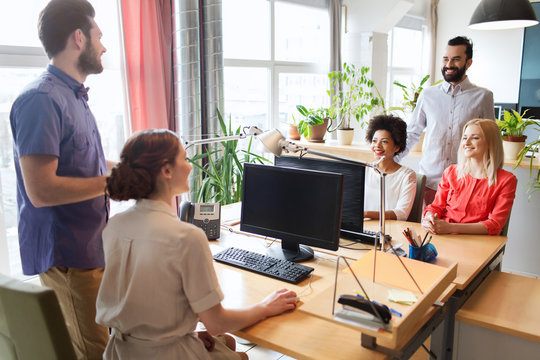 happy creative team talking in office