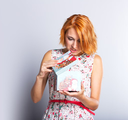 A beautiful slender girl with a gift box in her hands.

