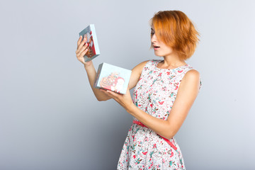 A beautiful slender girl with a gift box in her hands.
