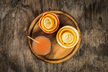 Citrus juice and fruits on vintage wooden background