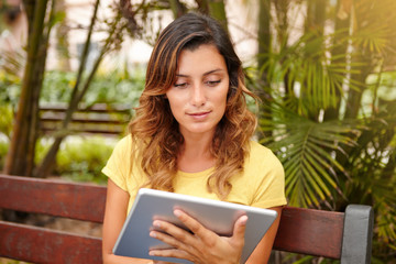 Fototapeta premium Caucasian lady browsing internet on tablet