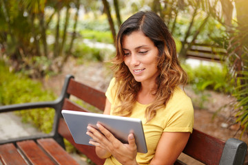 Fototapeta premium Cheerful woman browsing internet on tablet