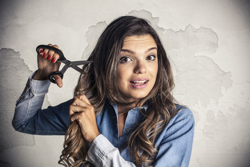 Beautiful girl cutting is own hair