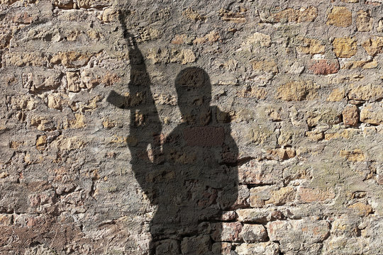Shadow of man holding rifle