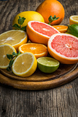 Halves of citrus fruits on wooden background. Orange, grapefruit