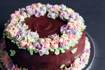 Obraz na płótnie Canvas Homemade chocolate cake with colorful cream flowers