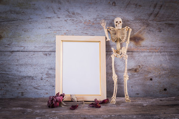 Still life Human Skeleton and Vintage photo frame on wooden background