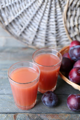 Delicious plum juice with fruits on wooden table close up