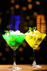 Glasses of cocktail on dark blurred lights background