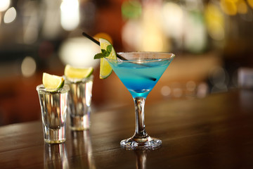 Glasses of cocktails on bar background