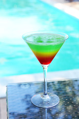 Cocktail on swimming pool background