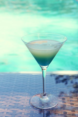 Cocktail on swimming pool background