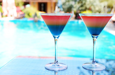 Cocktails on swimming pool background