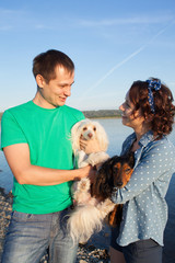 couple with their dogs on riverside