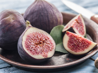 Ripe fig fruits on in the old tray on the wooden table.