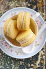 top view of vanilla macaroons in cup on wooden table