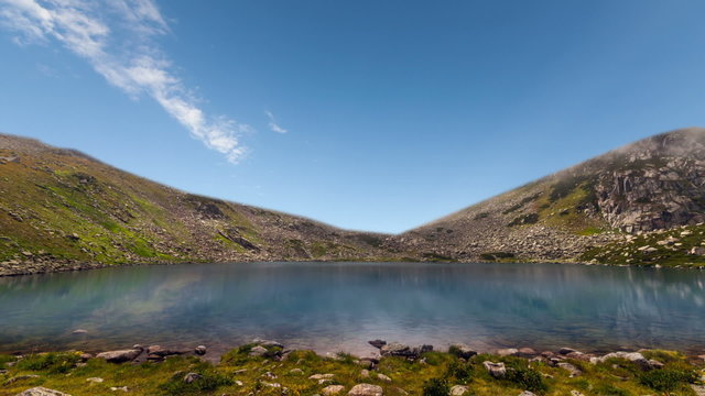 Mountain lake with reflection on the smooth water, timelapse of from day to nigh