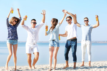 Obraz premium Young people with beer on the riverside
