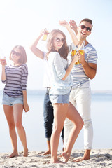 Obraz premium Young people with beer on the riverside