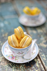 2 cups of vanilla macaroons on wooden table