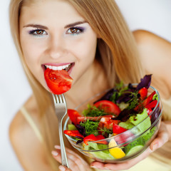 Happy woman making the salad 