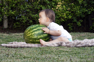 Baby hugging a watermelon