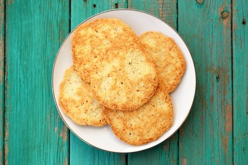 Tasty homemade almond cookies in white plate on turquoise vintag