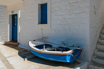 Fototapeta na wymiar Blue fishing boat outside a house in Peloponnese, Greece