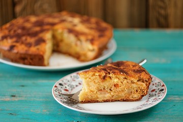 Homemade yummy apple pie with cinnamon and fork on turquoise tab