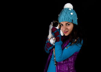 Teenage girl in winter clothes playing with her cat