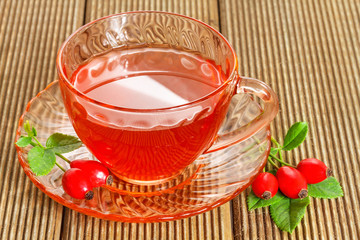 rose hip tea with fresh berries on the wooden background