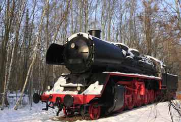 old, historic black-red steam engine in snow covered winterlandscape