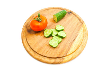 fresh cucumber and red tomato on cutting board